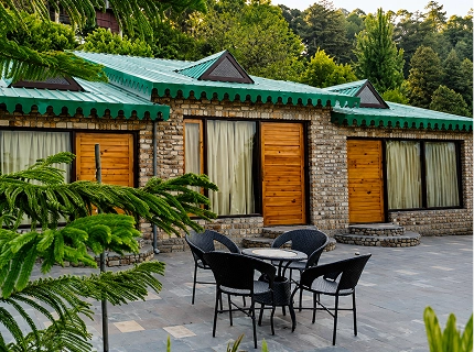 Stone cottage with a green roof and outdoor seating