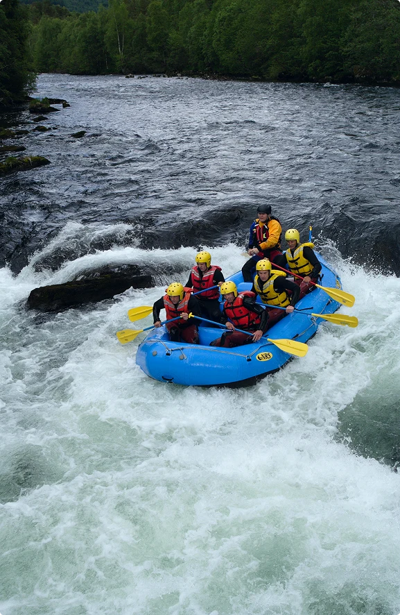 Group river rafting through white-water rapids