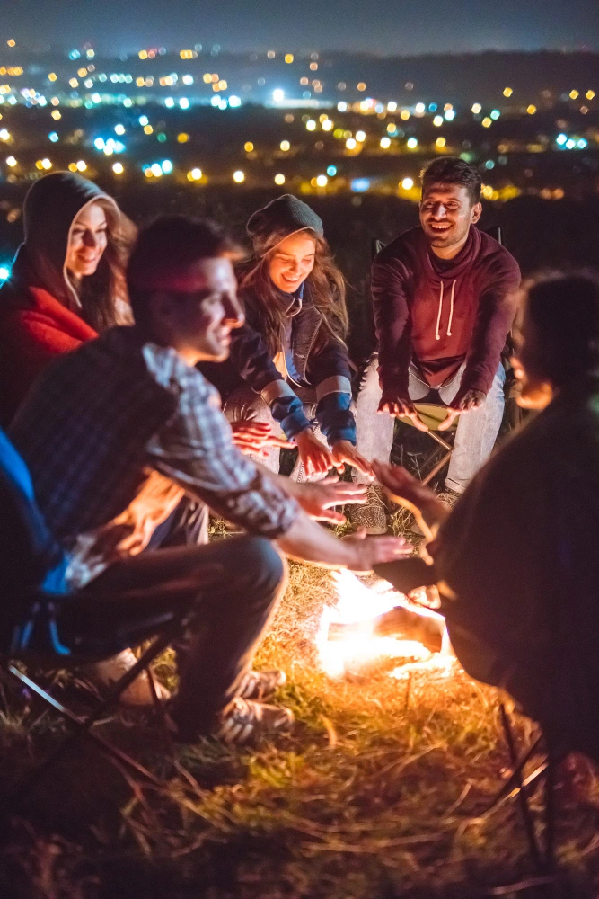 Friends gathered around a bonfire at night